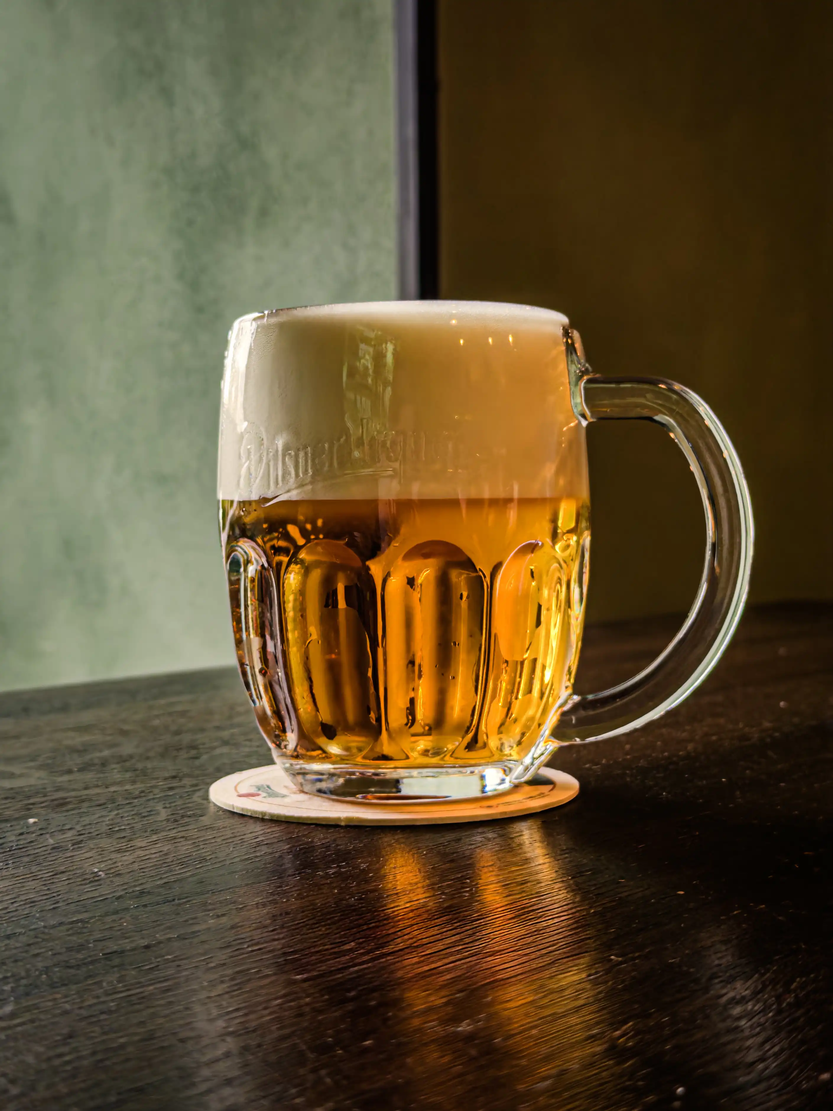 Plná sklenice Pilsner Urquell 12° na stolku v hostinci Školla Brno