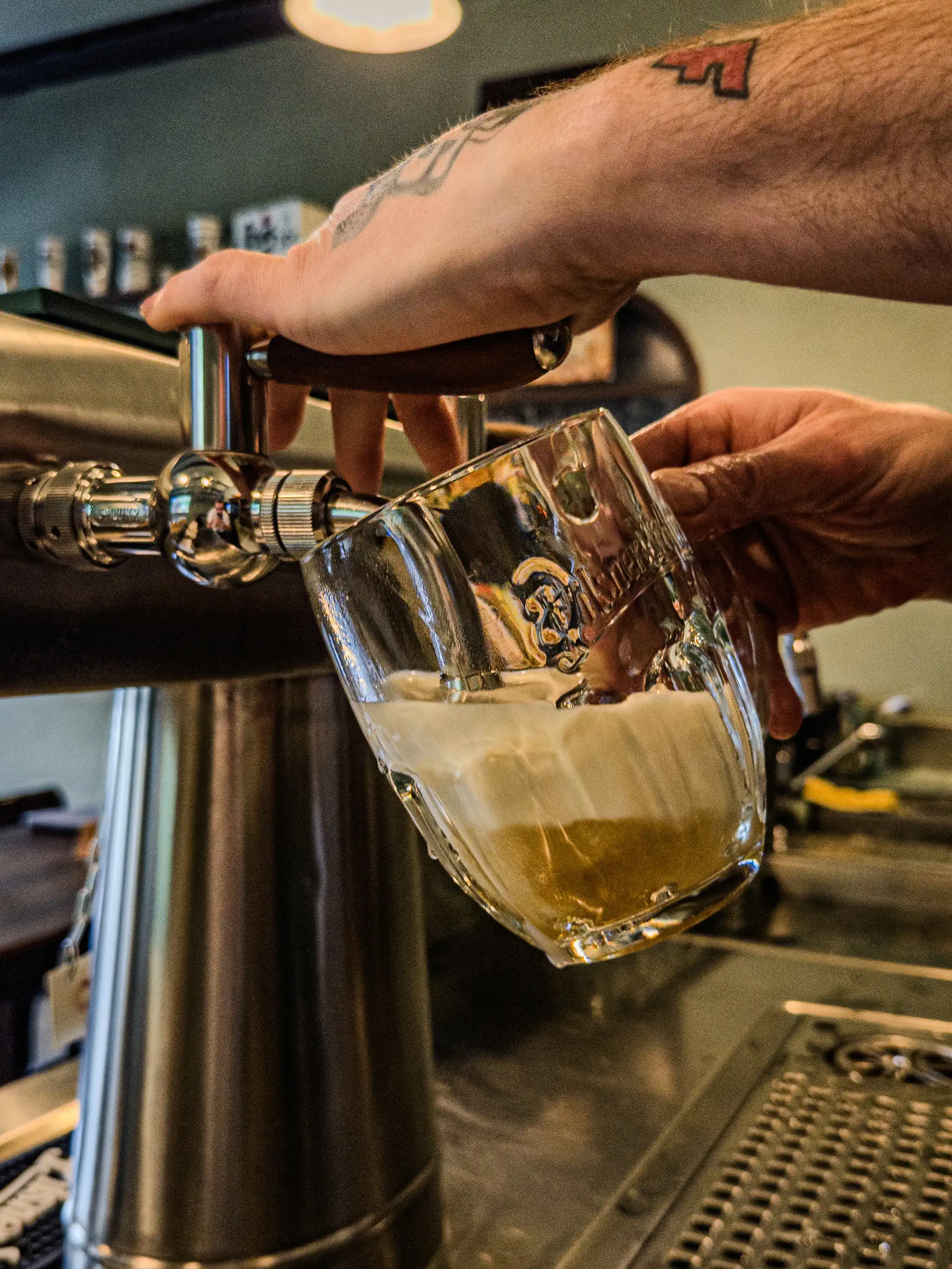 Šenkýř čepuje Pilsner Urquell do sklenice v hostinci Školla Brno